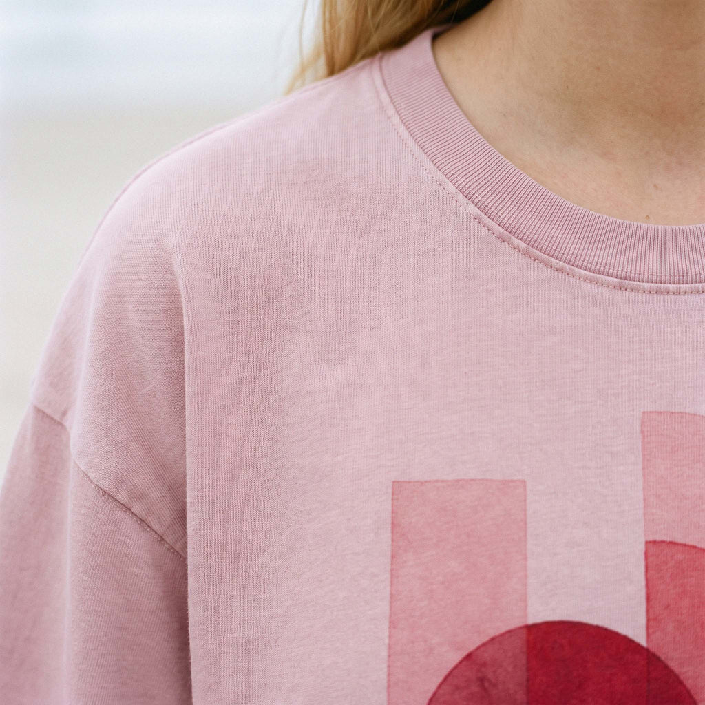 Fabric detail of the garment-dyed blush cotton jersey, ribbed collar and faded shoulder seam on AYLA – Oldest Daughter