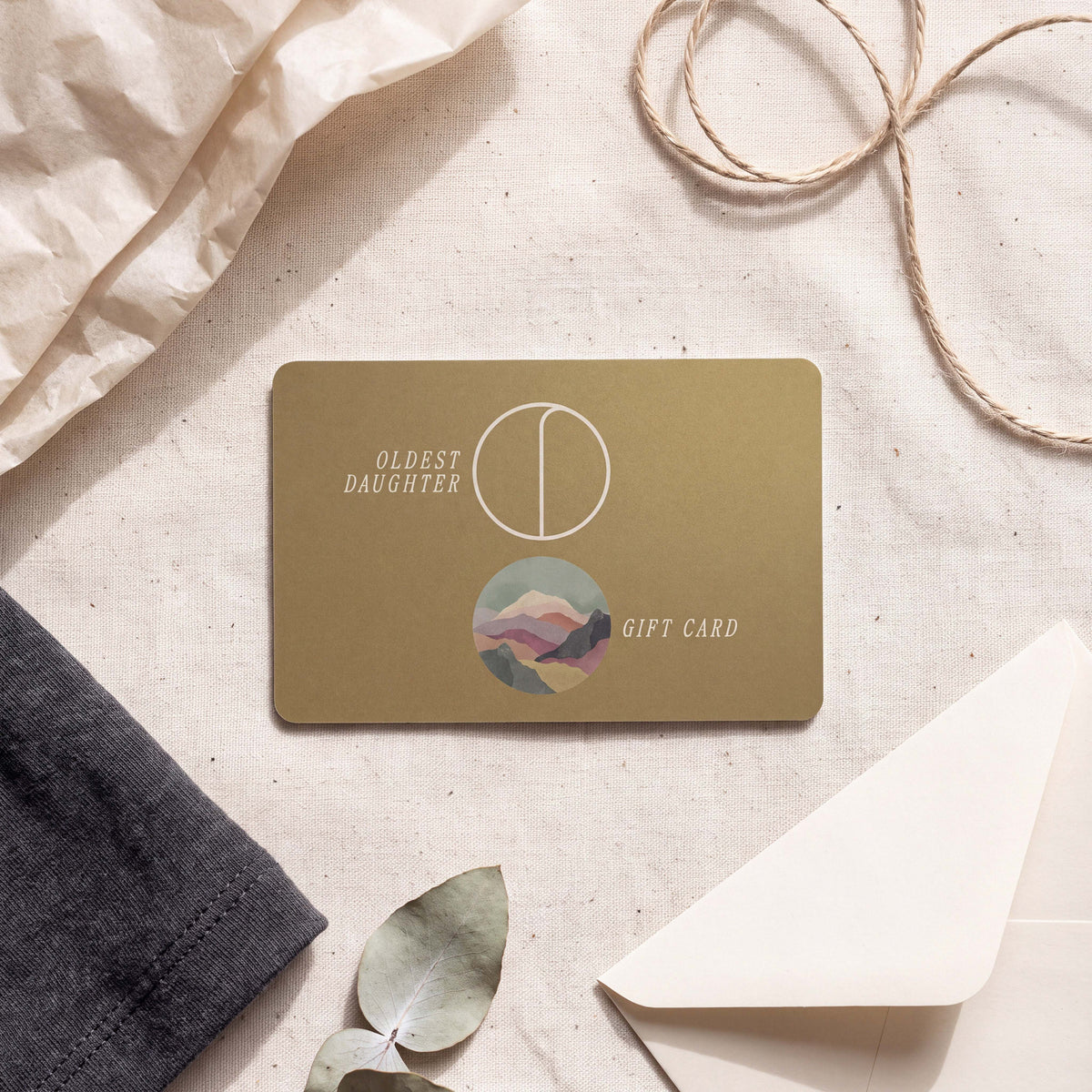 Oldest Daughter gift card in antique gold resting on natural cotton canvas