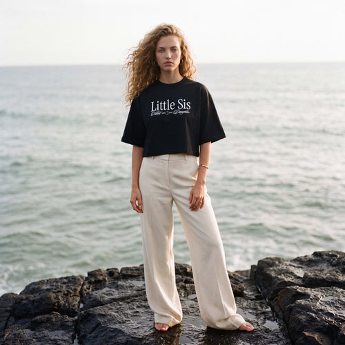 Model wearing the black LILLE cropped boxy tee with the Little Sis print – Oldest Daughter, Byron Bay