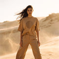 Model wearing the SANDI oversized boxy tee in sand recycled and organic cotton – Oldest Daughter, Byron Bay