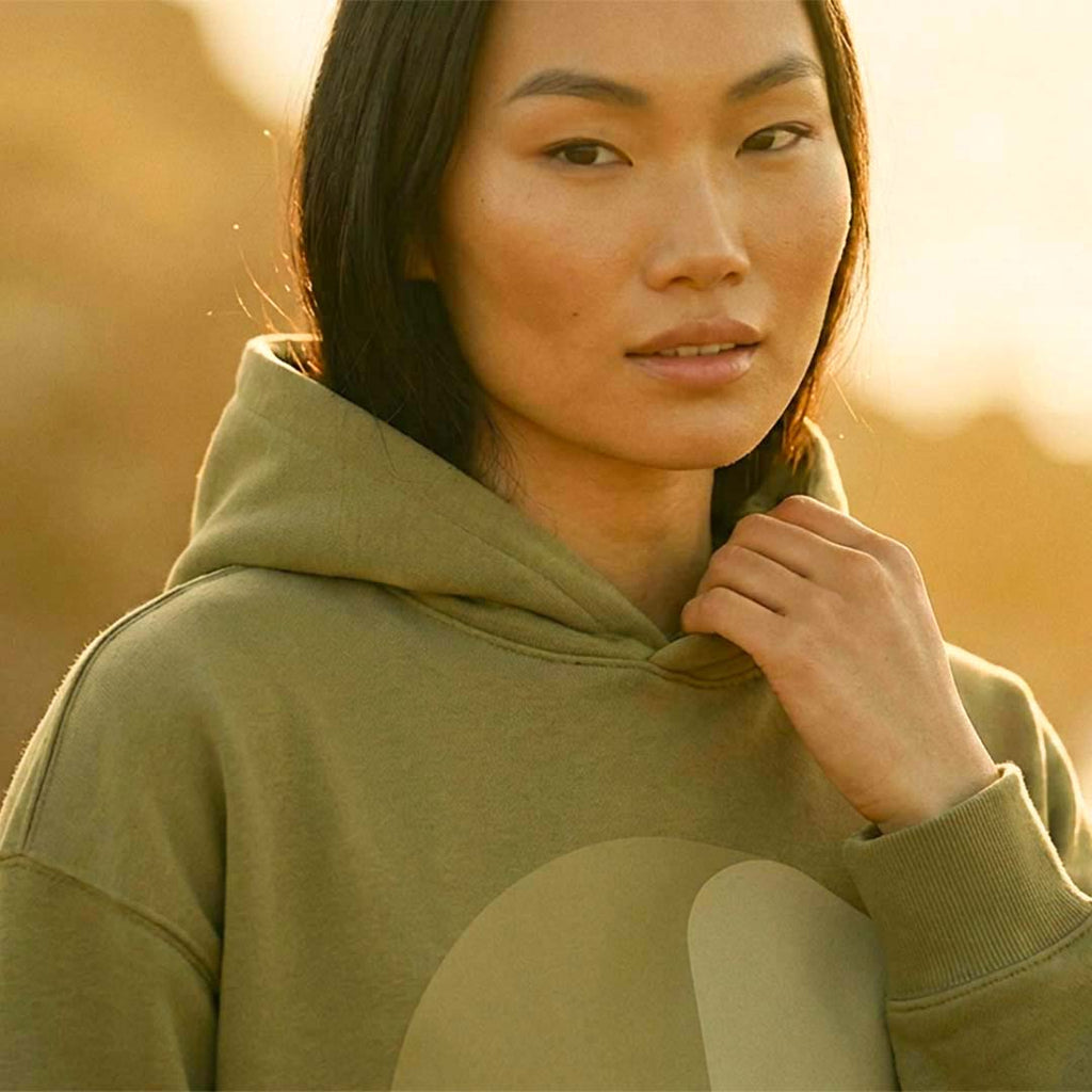 Model wearing the YARA extra-oversized hoodie in faded olive organic cotton – Oldest Daughter