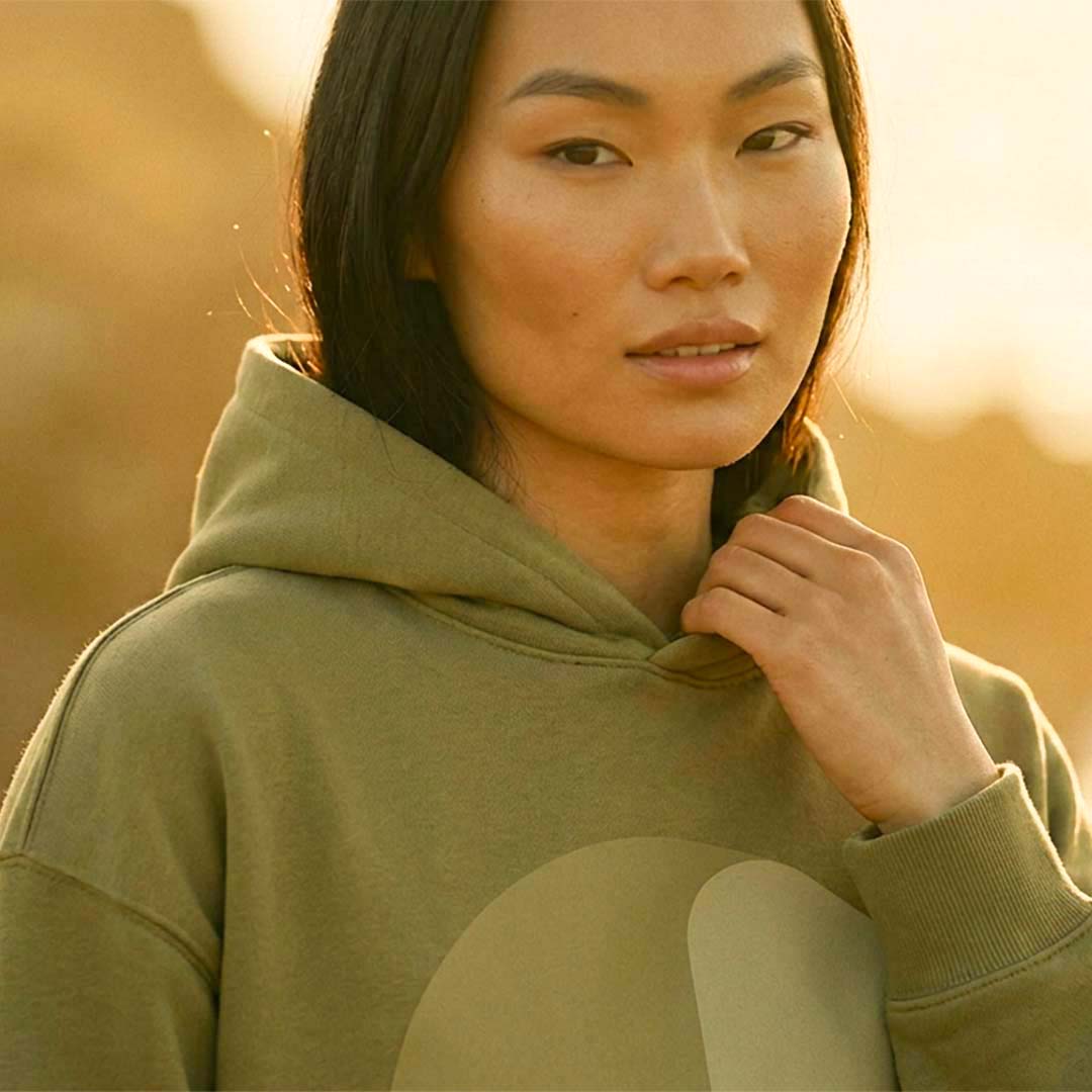 Model wearing the YARA extra-oversized hoodie in faded olive organic cotton – Oldest Daughter